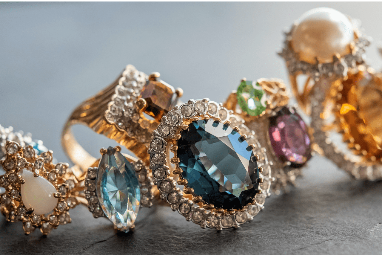 A close-up of multiple different colored jewelry pieces on a concrete surface.