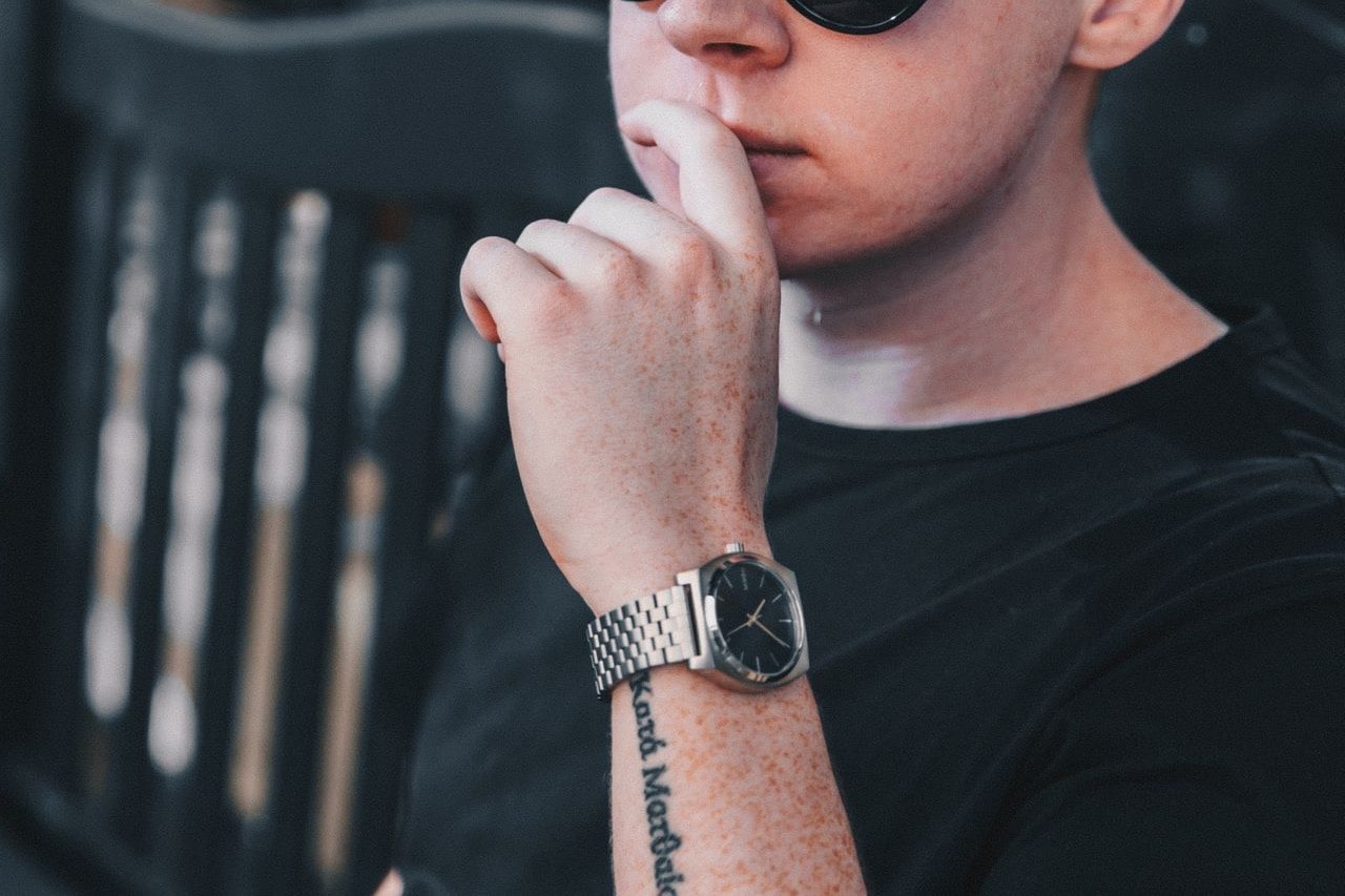 A casually-dressed man wearing an elegant wristwatch.