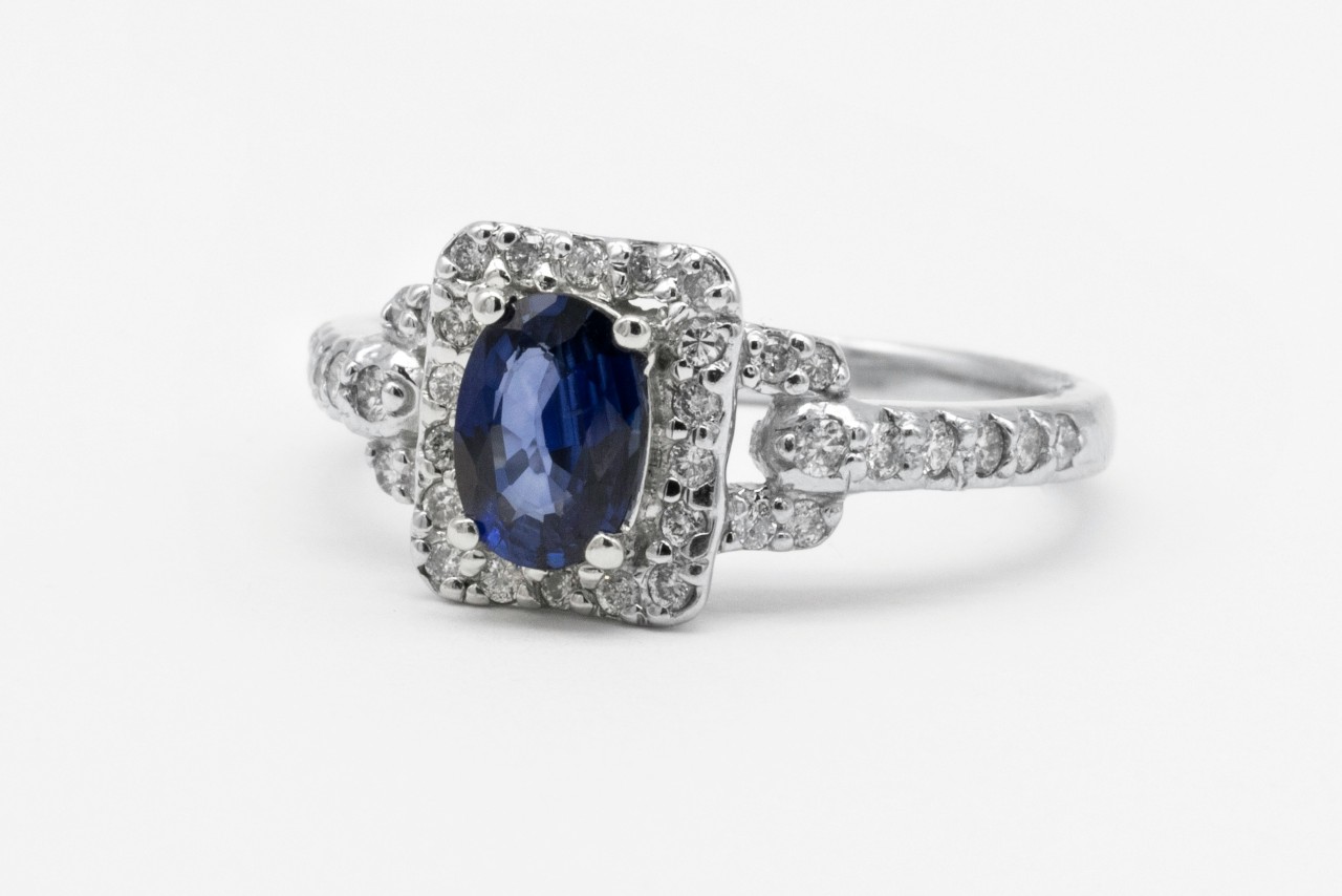 close up image of a white gold and diamond engagement ring with a sapphire center stone close up image of a white gold and diamond engagement ring with a sapphire center stone