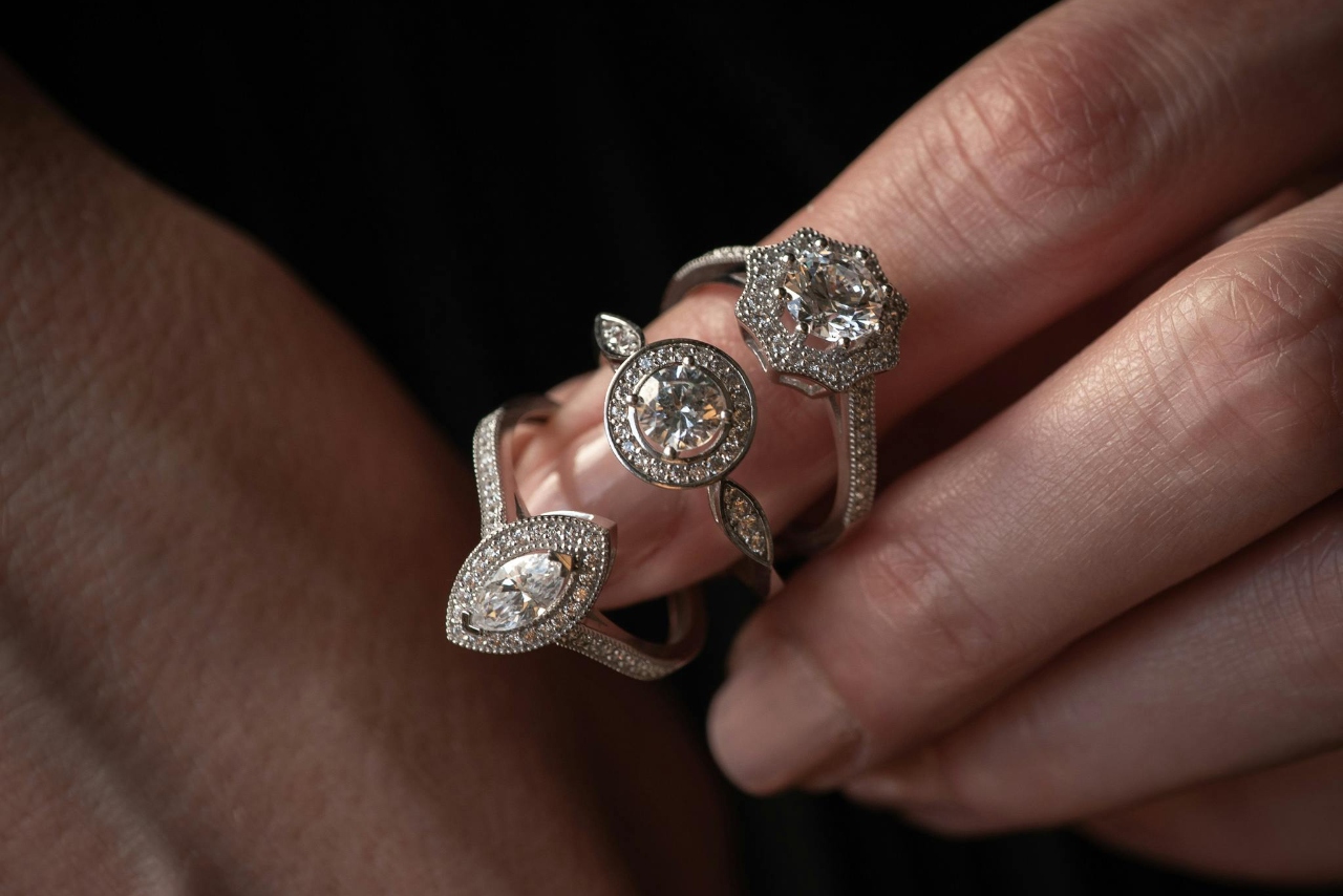 Three white gold side-stone engagement rings with different center stone shapes