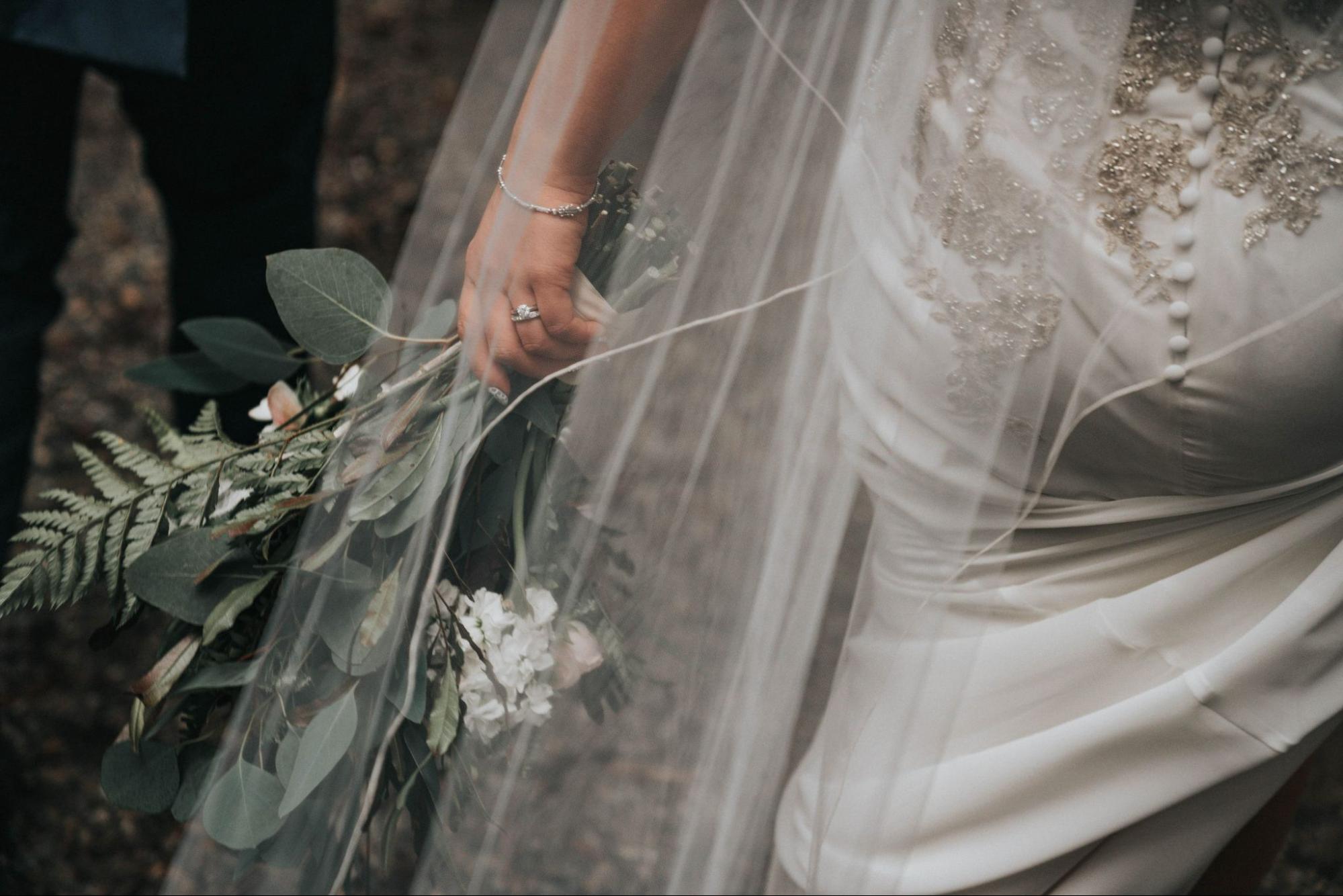 A bride holds her bouquet as she walks back down the aisle with her groom.