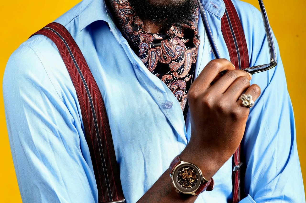 a man in a blue shirt lifting his glasses and wearing a skeleton dial watch a man in a blue shirt lifting his glasses and wearing a skeleton dial watch