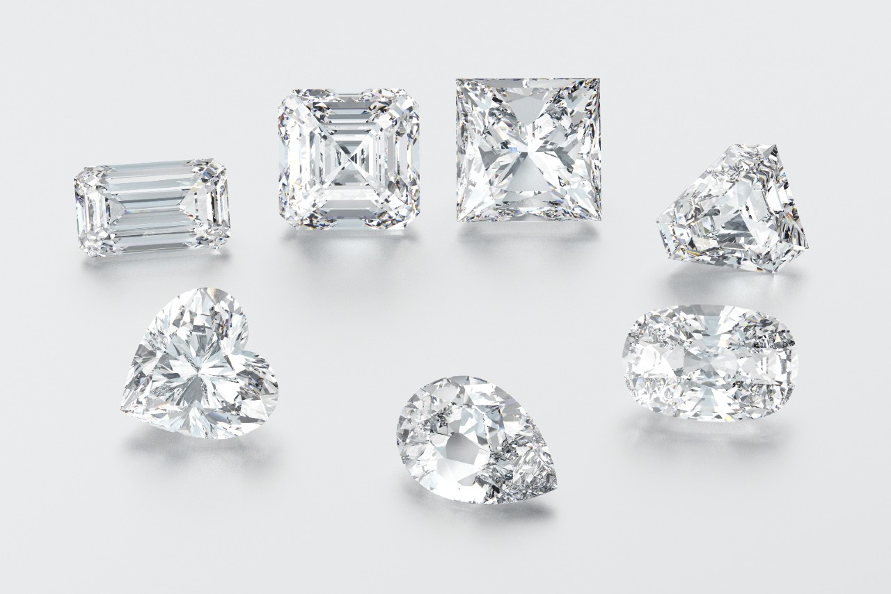 A close-up of a variety of diamond cuts on a white background. A close-up of a variety of diamond cuts on a white background.
